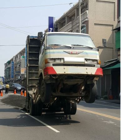 一台滿載砂石的貨車，行經台林街時，後車斗往後倒造成翹孤輪。（讀者提供）