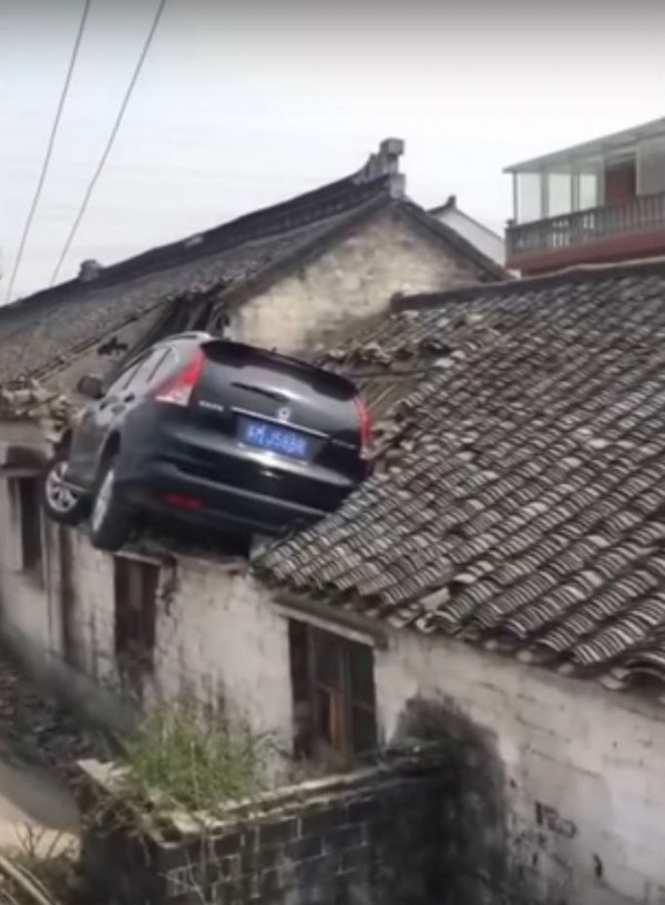 中國江蘇超離奇車禍，1輛休旅車竟然直直衝到民宅屋頂卡在上面。（圖擷自YouTube）