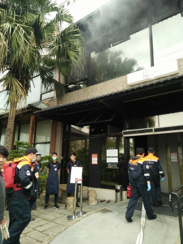 新竹縣竹北市1家燒肉店今天中午用餐時段發生火警，2樓竄出濃煙，現場顧客、員工緊急疏散，消防隊員入內搶救。（圖由新竹縣消防局提供）