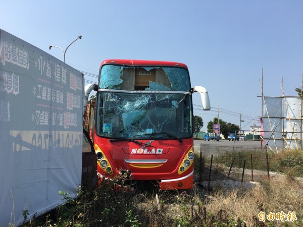 日統客運公司遊覽車疑為閃避左轉機車失控撞上分隔島的號誌桿，幸無人員傷亡。（記者黃淑莉攝）