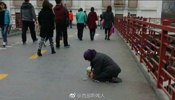 中國職業乞丐亂象頻傳，有好心人給了她食物，卻被職業乞丐丟掉。（圖擷取自微博）