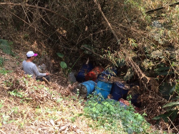 裝置汙泥鐵桶被推入山溝。（記者洪臣宏翻攝）