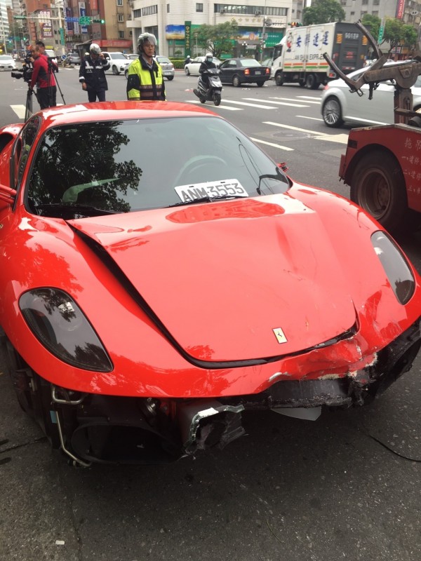 紅色超跑與重機車發生擦撞車禍，由於撞擊力道太大，超跑車頭毀損嚴重。（記者邱俊福翻攝）