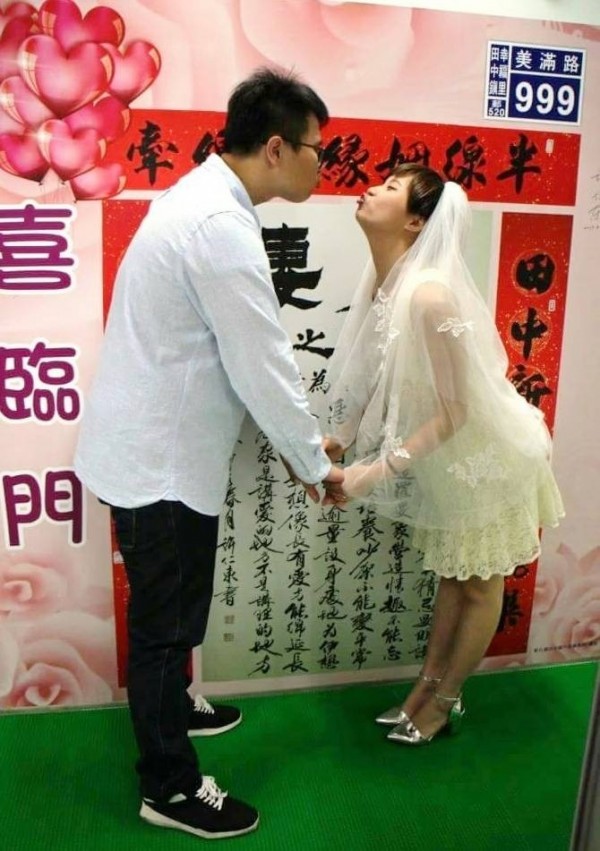 辦理結婚登記新人，活潑的在文字牆前搞笑拍照留念。（記者陳冠備翻攝）