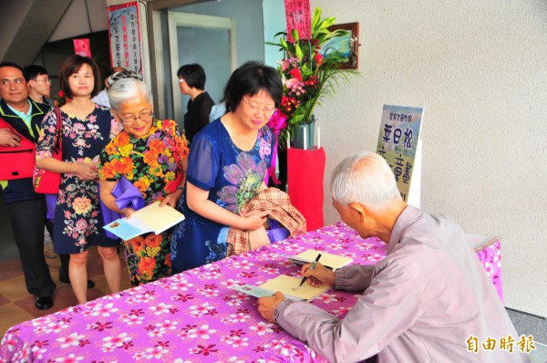 客家詩人葉日松為讀者新書簽名。（記者花孟璟攝）