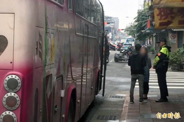 朱姓遊覽車司機（背對者）被查獲酒駕，連絡友人將車領回，遊客則搭乘另一部接駁車繼續旅程。（記者陳恩惠攝）