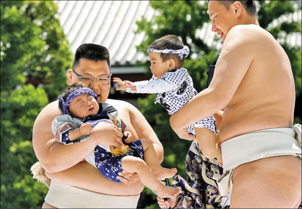 東京淺草寺四月三十日舉辦年度「哭泣相撲」，兩名力士抱起未滿一歲的幼兒，較量手上的寶寶誰先哭，或誰的哭聲較大。（歐新社）