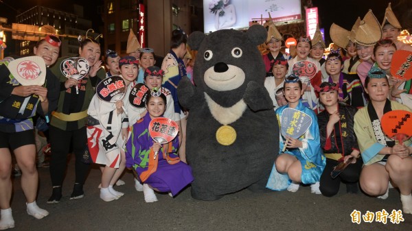 台北市松山區「錫口文化節」30日邀請日本東京阿波踊舞者進行踩街舞蹈表演，世大運吉祥物熊讚也現身，跟著一同起舞並和舞者合影。（記者張嘉明攝）