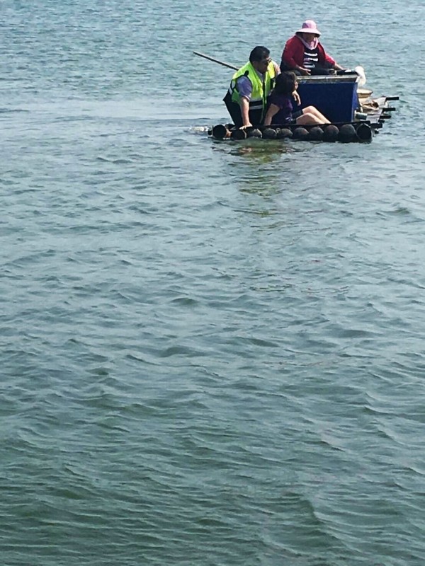 台西派出所警員黃寶進搭竹筏跳進魚塭搶救尋短婦人。（記者黃淑莉翻攝）