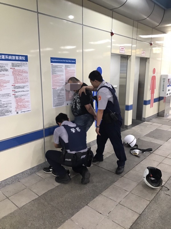 毒品通緝犯梁鶴瓊拒捕，在捷運江子翠站朝盤查他的交通分隊長林家銘、警員莊進忠及吳鎮宇3警噴灑辣椒水，3警強忍嗆辣，逮獲梁嫌。（記者吳仁捷翻攝）