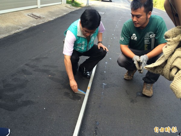 楊典忠為瞭解道路工程查驗流程，與查驗小組實地測試鑽心機器與平整器。（記者黃鐘山攝）