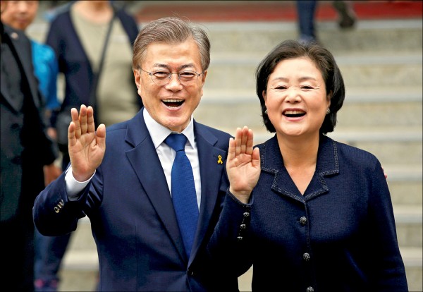 文在寅與妻子金正淑（譯音）九日前往首爾的投票站投票時，與支持者握手致意。（路透）