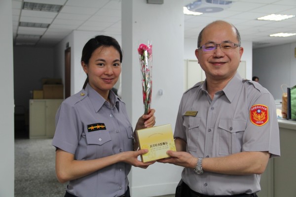 淡水警分局長親自向女警獻上康乃馨及蛋糕，感謝她們工作上的辛勞。（記者王宣晴翻攝）