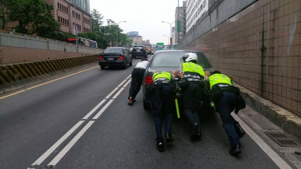 台北市基隆路車行地下道有車拋錨，信義分局員警合力推車爬坡200公尺。（記者姚岳宏翻攝）