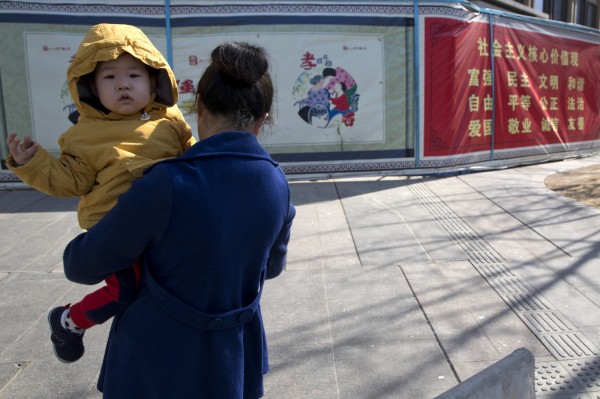 雲南省普洱市傳出要求辦理「準生證」的民眾，得出示證明「我老婆是我老婆」。圖為一位中國女性抱著孩子，與本新聞無關。（美聯社）