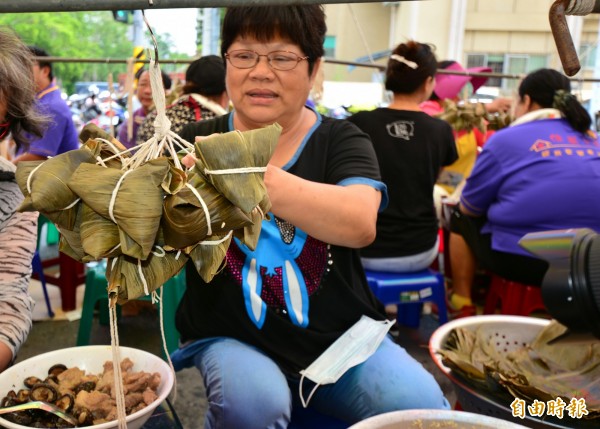 北台南家扶中心佳里展愛志工隊送愛心粽，弱視單親媽蔡惠美用心包粽，堅韌生命力感動志工。（記者王涵平攝）