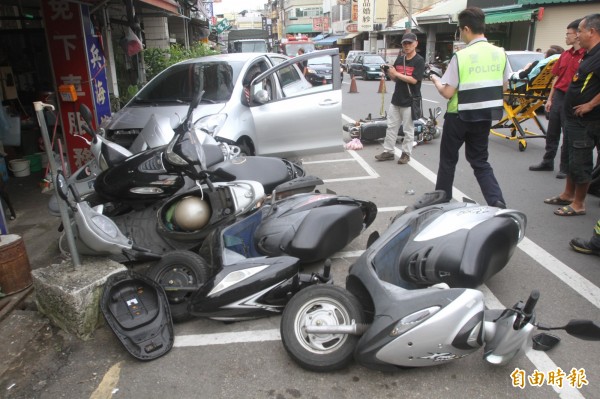 轎車失控衝向路旁，機車像保齡球般倒8輛。（記者蔡政珉攝）