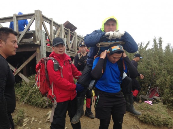 蔡男因受傷無法行走，由高山協作的山青輪流揹下山。（記者歐素美翻攝）