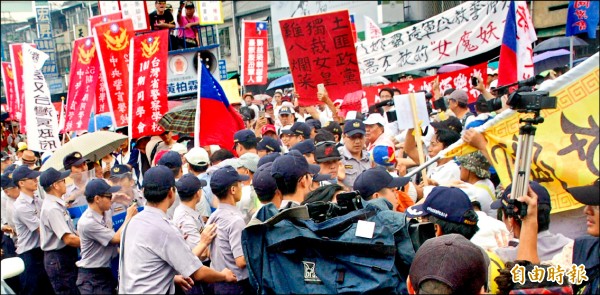 反年改群眾在屏東演藝廳外抗爭，數度與警方發生推擠，警方舉牌制止非法行為，場面險些失控。（記者李立法攝）