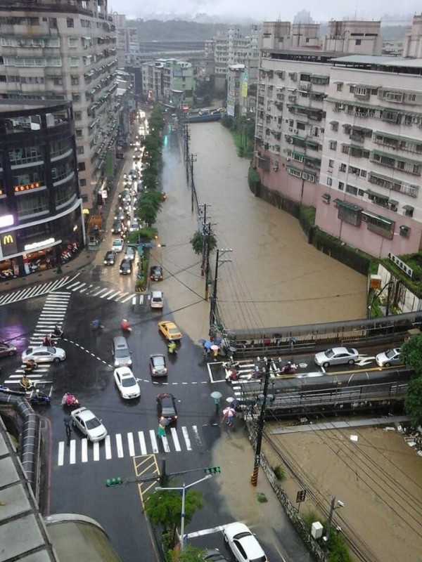 今晨暴雨造成武崙溪越堤，基金一路雙向車道全泡水，嚴重影響車輛通行。（記者林嘉東翻攝）