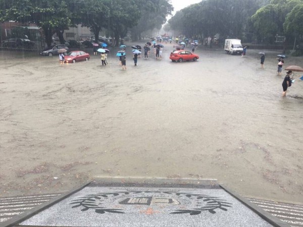 輔大淹水情況嚴重，人、車涉水而行。（輔大學生提供）