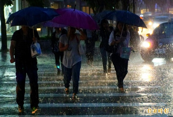 梅雨鋒面今日轉回北部，下午大台北地區降下大雨，讓正逢下班尖峰時間的民眾苦不堪言。（記者鹿俊為攝）