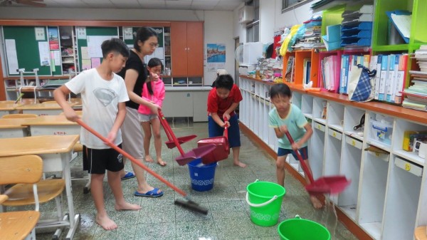 二日一場豪大雨造成北市不少學校淹水受災，圖為北市大佳國小校方清理環境。（大佳國小提供）