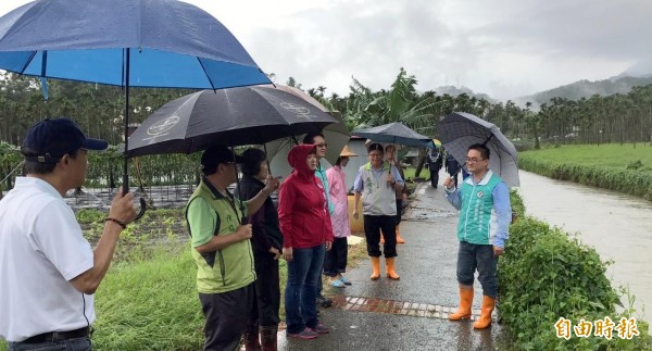 民進黨南投縣黨部執行長曾琮愷（右），陪同立委蔡培慧（左4紅雨衣者）等人，前往日月潭頭社盆地了解絲瓜受損情形。（記者謝介裕攝）