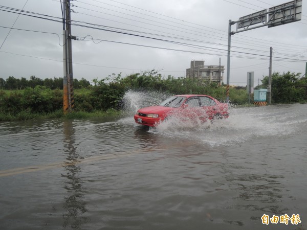 台西雲155線今晨積水嚴重，車輛行經濺起大量水花，猶如陸上行舟。（記者陳燦坤攝）