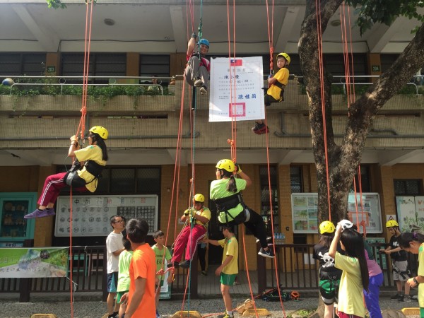 中湖國小為40名應屆畢業生舉辦成年禮，攀爬上校園內的老茄苳樹及老樟樹，在樹上領取畢業證書。（中湖國小提供）