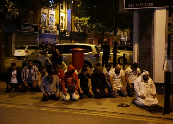 汽車衝撞後，許多穆斯林在現場為受害者禱告。（法新社）