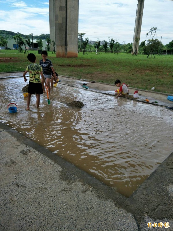 平鎮運動公園連日梅雨過後、沙坑變水池，小朋友玩沙變玩沙水。（記者李容萍攝）