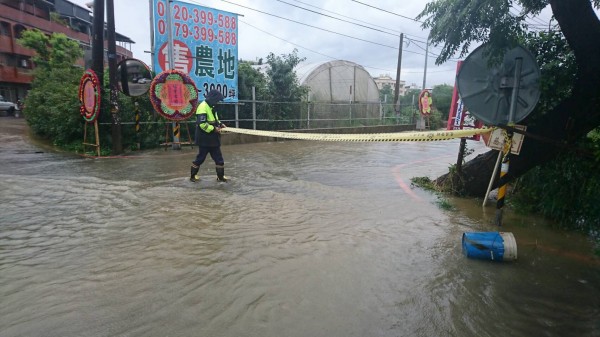 龍潭區民生路、富華街口水深約15公分，龍潭警分局石門派出所員警在現場交管。（記者李容萍翻攝）