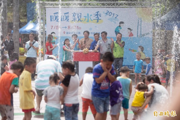 天氣如此炎熱，暖暖親水季活動熱鬧登場，在忽高忽低的噴水設施裡，大小朋友被水扁得好不痛快。（記者林欣漢攝）