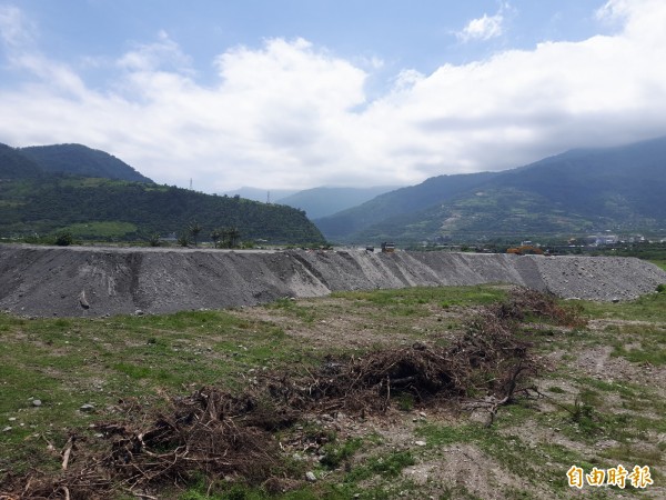 知本溪疏濬砂石堆置在堤防後方，引發卡大地布部落族人不滿，要求遷移他處。（記者陳賢義攝）