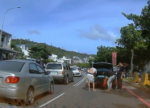 賓士車紅線佔車道上下車整理行李、還更衣。（記者蔡宗憲翻攝）