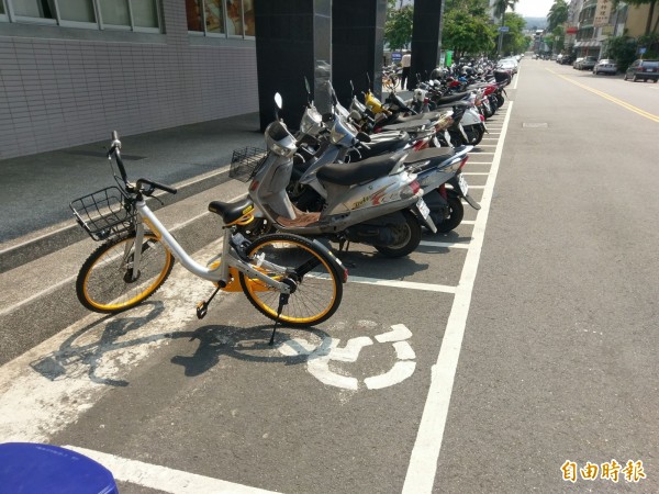 無樁共享自行車oBike進駐南投縣各地，惟在南投市鬧區卻有oBike單車違規停放在殘障機車格，民眾看得直搖頭。（記者劉濱銓攝）