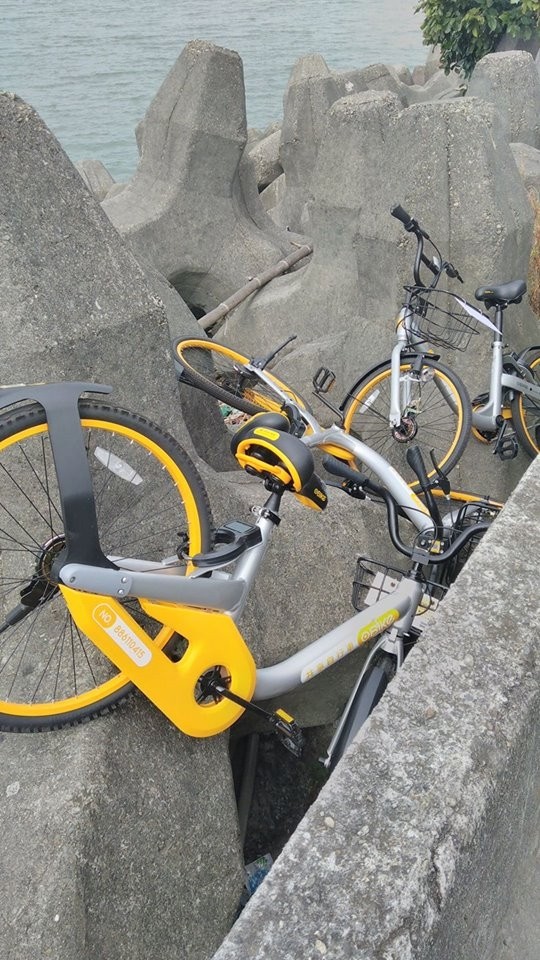 遭人發現棄置在漁人碼頭消波塊上的oBike。（記者李雅雯翻攝）