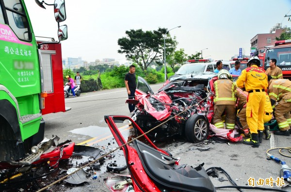 轎車駕駛受困，消防隊全力搶救。（記者吳俊鋒攝）