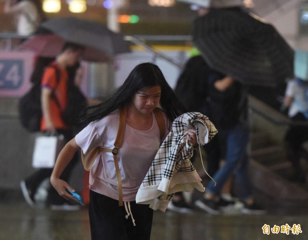 尼莎颱風襲台，28日晚間台北街頭開始出現間歇性風雨，雖然雨勢不大，卻也讓措手不及的行人吃足苦頭。（記者廖振輝攝）