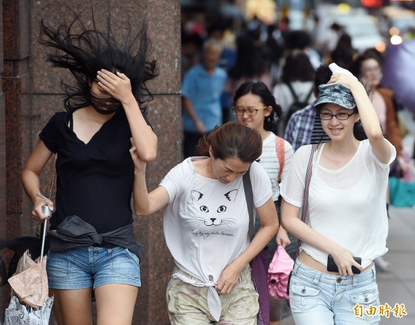 圖為颱風襲台前夕，間歇性的陣風挾帶雨勢，讓台北街頭的行人吃足苦頭。（資料照，記者廖振輝攝）