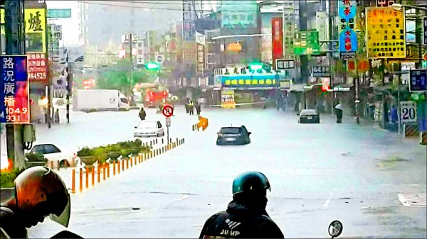 南市仁德中山、中正路口傳出災情，嚴重積水，車行困難，機車騎士更只能「望水興嘆」。（記者吳俊鋒翻攝）