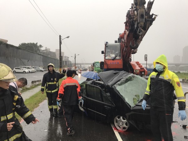 新北市新莊區重新堤外便道接近新月橋下方，轎車打滑撞對向吊車，駕駛送醫急救中（消防局提供）