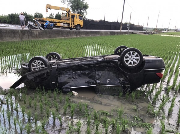 發生車禍的三菱轎車，衝進田中翻覆。（記者林宜樟翻攝）