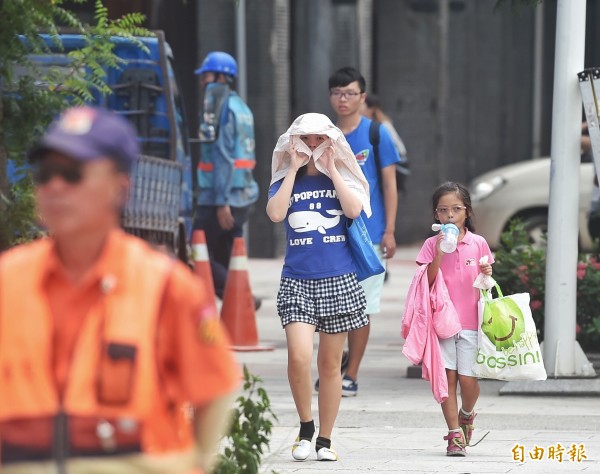 今天全台天氣炎熱，民眾需適時補充水分，午後仍有降雨機率，民眾午後出門應攜帶雨具備用。（資料照，記者方賓照攝）