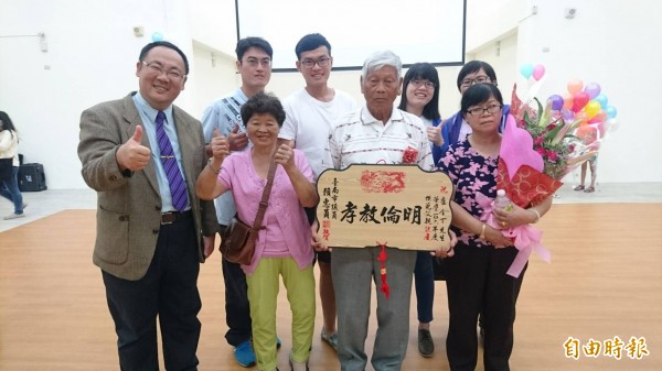 81歲盧金丁（前右二）代表柳營獲選台南市大樹爸爸，由區長李宗翰表揚（左一），4名孫子和太太、女兒陪同領獎。（記者楊金城攝）