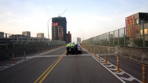 警方協助將拋錨的跑車推離中豐陸橋。（記者周敏鴻翻攝）