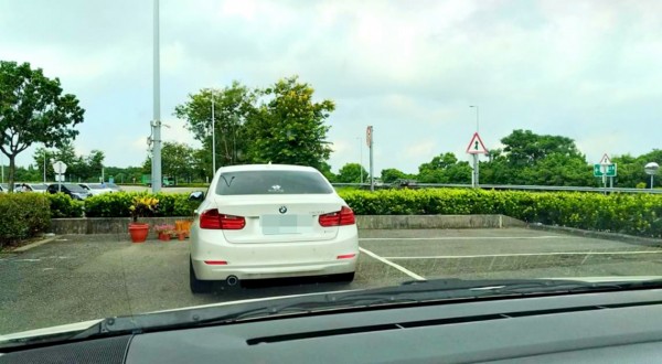 白色名車停在車格外，讓其他車子無法停進停車格。（林姓民眾提供）