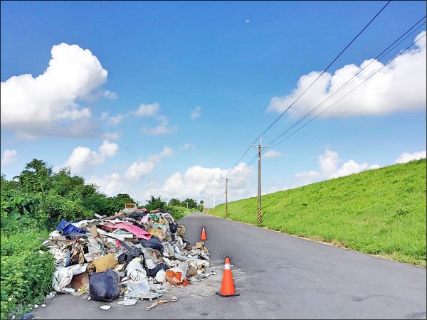 曾文溪南岸道路，遭人棄置一大堆廢棄物。（翁育民提供）