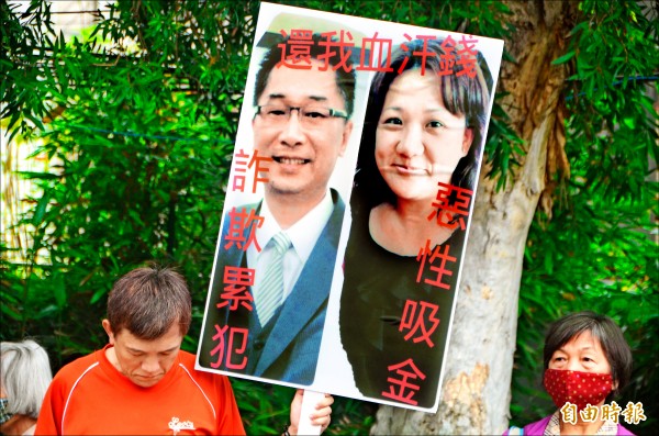 受害人在前年曾高舉王啟訓、許仟垣夫妻檔照片,怒喊「還我血汗錢」。(資料照,記者鄭淑婷攝) 受害人在前年曾高舉王啟訓、許仟垣夫妻檔照片,怒喊「還我血汗錢」。(資料照,記者鄭淑婷攝)